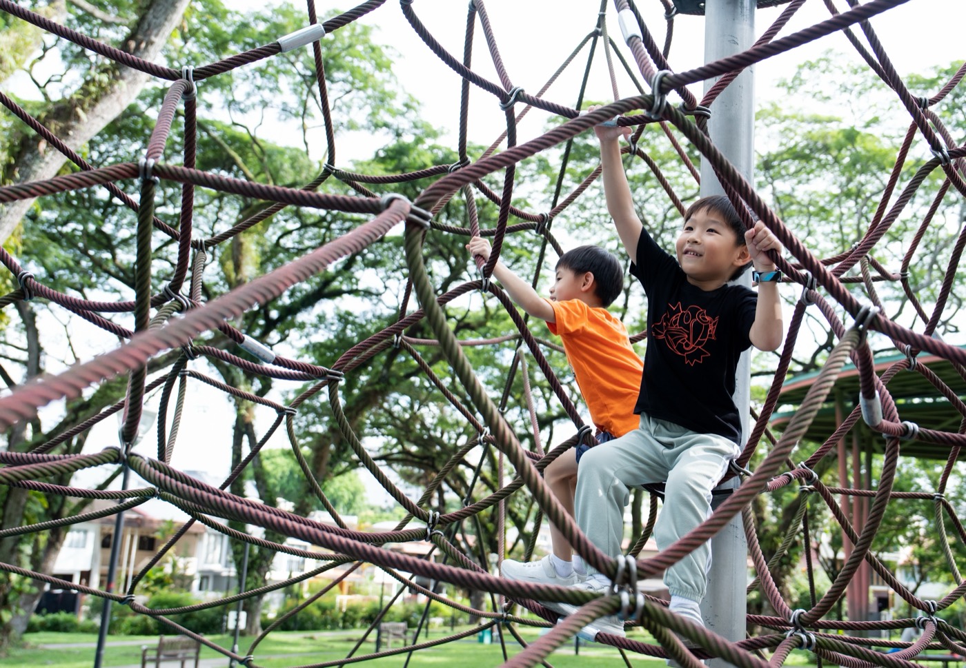 Children playing on a climbing net at a Singapore playground